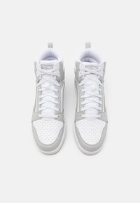 Baskets montantes de sport avec une base blanche et des accents gris, un bout perforé, des lacets plats et un col rembourré pour le soutien.