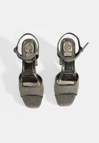 Grijze glitter hoge hakken sandalen met een kruisriemontwerp, open teen en enkelriem. Gladde glanzende zool en gestructureerde stof.