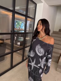 Vestido cinza oversized com padrões de conchas e estrelas-do-mar; tecido suave; design off-the-shoulder; mangas longas; ajuste relaxado.