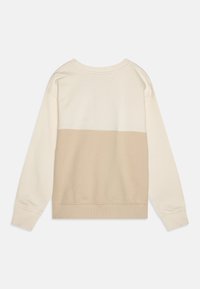 Beige og kremfarget fargeblokkert sweatshirt med rund hals, lange ermer og ribbede mansjetter og kant. Mykt, strukturert stoff.