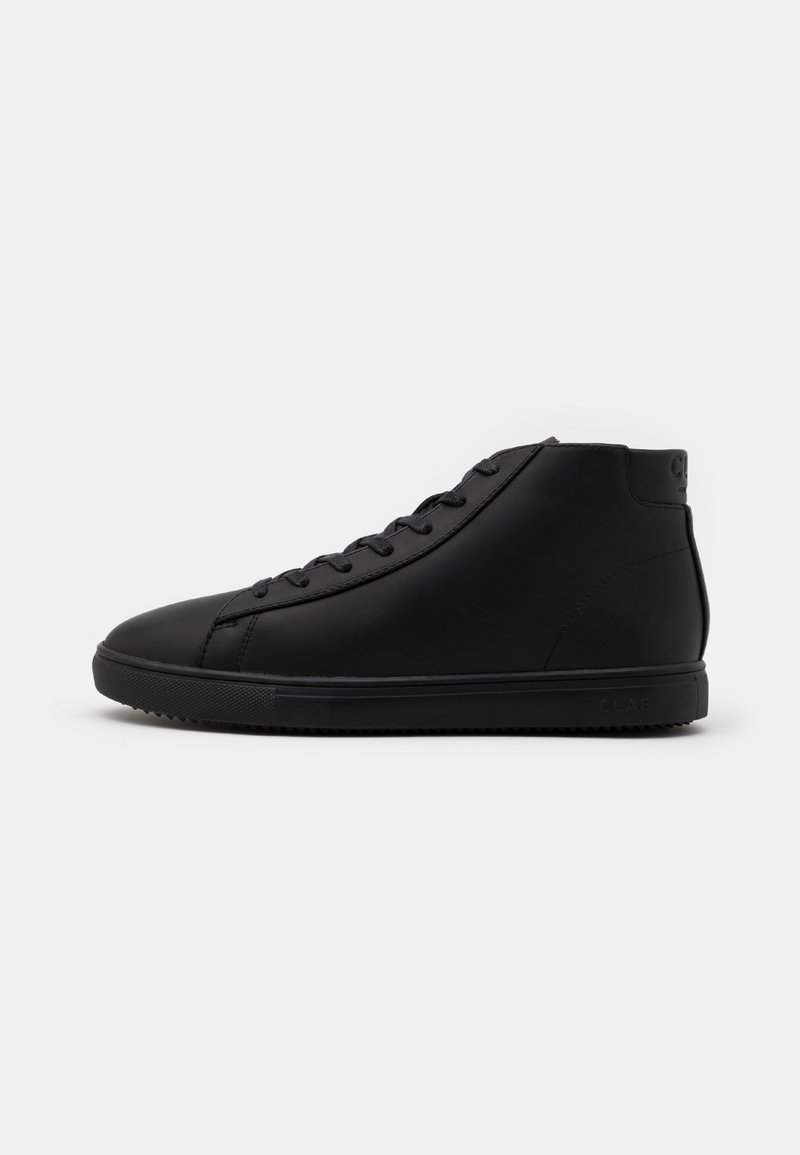 Baskets montantes noires avec fermeture à lacets, tige en cuir lisse et semelle en caoutchouc texturée, présentées de profil sur fond blanc.