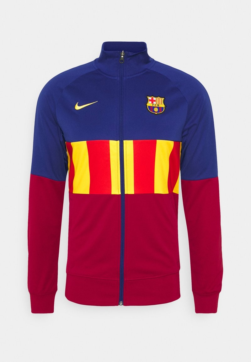 Nike FC Barcelona track jacket featuring red and yellow stripes on the chest, with blue sleeves and a zip-up collar. Team logo on the front.