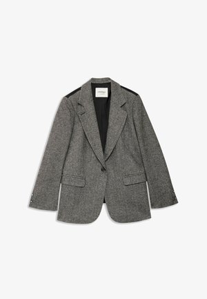 Sivý blazer v rybacej kosti so štruktúrovaným dizajnom, klopovými goliermi, dvoma prednými vreckami a čiernymi akcentmi na pleciach. Zapínanie na jeden gombík.