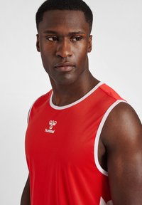 Rød atletisk tanktop med hvide accenter og logo. Lavet af glat stof, har en rund halsudskæring og ærmeløst design.