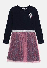Abito a maniche lunghe con parte superiore blu navy, fascia argentata in vita e gonna in tulle rosa con motivi di stelle e pois multicolori. Applicazione di unicorno sul petto.
