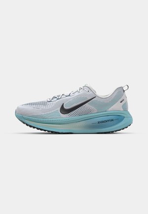 Zapatilla de running ligera con parte superior de malla transpirable en tonos de gris y azul, que presenta un swoosh negro y una suela texturizada para tracción.