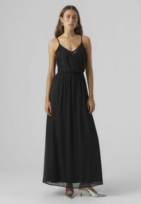 Robe maxi noire avec décolleté en V et fines bretelles, dotée d'une taille froncée et de détails en dentelle au niveau du col. Tissu lisse et léger.
