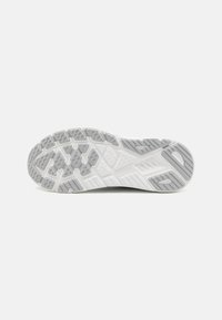 Sole of a sneaker featuring a rubber material, patterned gripping surface, light grey and white colors, and textured accents for traction.