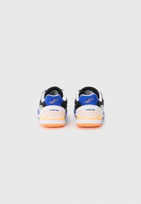 Black and white athletic shoes with orange soles and blue accents. Mesh upper with stitched details; features logo and vented sides.