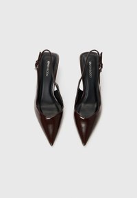 Ruske nubuk slingback pumpe s upernim nosom, glatkom teksturom i podesivom remenom oko gležnja. Crni uložak s vidljivim logotipom brenda.
