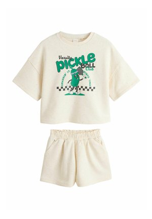 Cream short-sleeve crop top and matching shorts set with green pickle cartoon and "Varsity pickleball club" text on top.