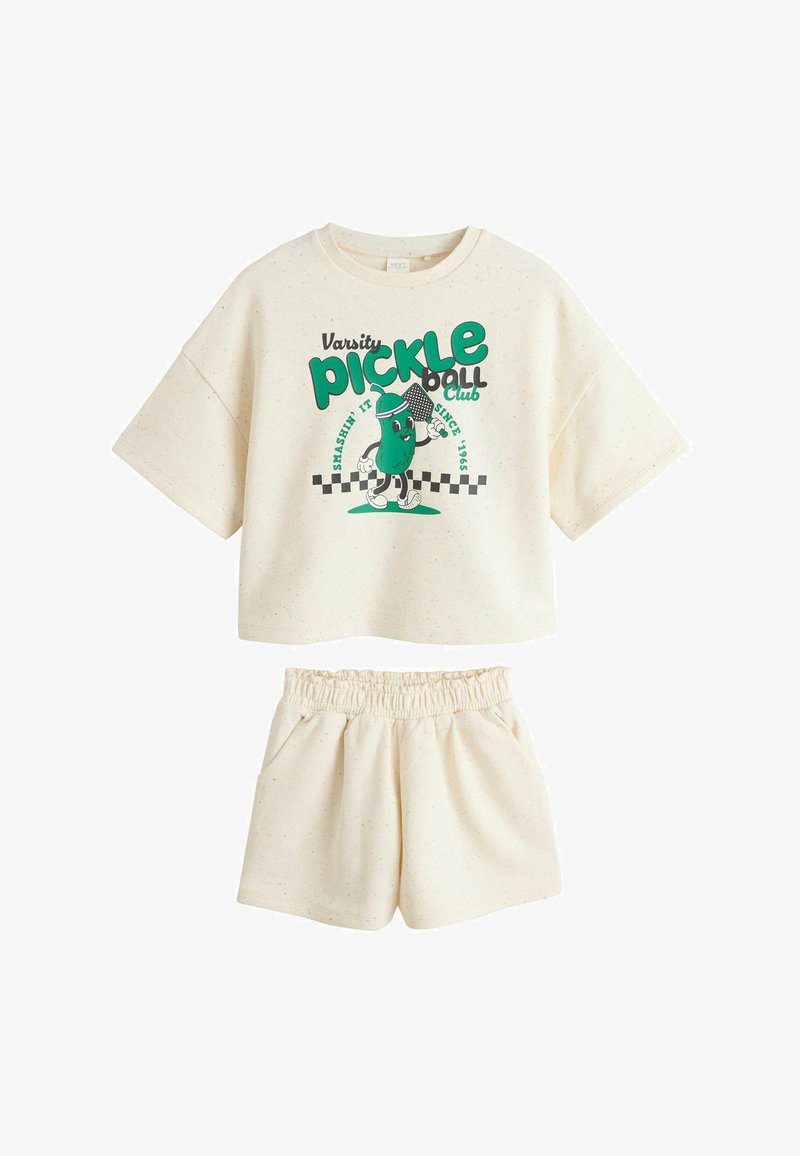 Ensemble crop top à manches courtes crème et short assorti avec un dessin animé de cornichon vert et le texte « Varsity pickleball club » sur le haut.