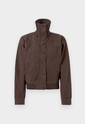 Chaqueta ligera marrón con un alto cuello, cierre de botones, dos bolsillos laterales y dobladillos y puños acanalados, que presenta una textura de tela suave.