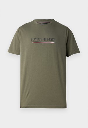 Olivgrünes Baumwoll-T-Shirt mit kurzen Ärmeln, das das "TOMMY HILFIGER"-Logo in Marineblau und roten Akzenten über die Brust zeigt. Runder Halsausschnitt.