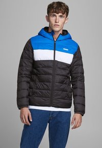 Gewatteerde jas met een zwarte romp, blauwe capuchon en witte horizontale streep. Voorzien van een ritssluiting, zijzakken en een doorgestikt design.
