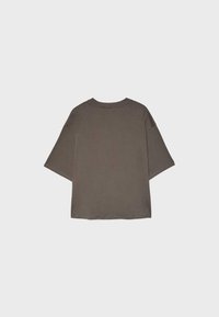 T-shirt oversize gris foncé uni à manches courtes et col rond, présenté de dos sur un fond gris clair.