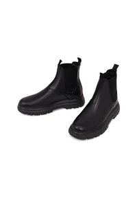 Botas de cuero negro hasta el tobillo con paneles laterales elásticos, acabado suave, parte trasera texturizada y suela de goma con un patrón de relieve.