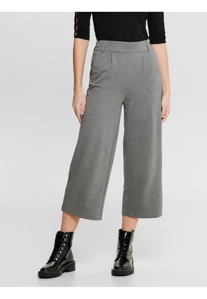 Szare, szerokie culottes wykonane z miękkiego materiału, z płaskim przodem i bocznymi kieszeniami. W połączeniu z czarnymi butami na sznurowadła.