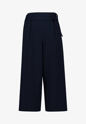 Marineblå, vidde bukser med korte ben, højt liv og en stofrem bundet i en knude på højre side.