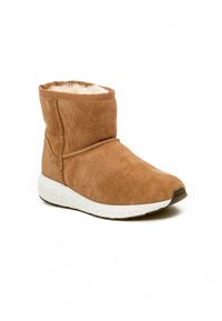 Tan ruskinds ankelstøvle med blødt pelsfor og en hvid skumsål; har en rund tå og syet detaljering langs siderne.