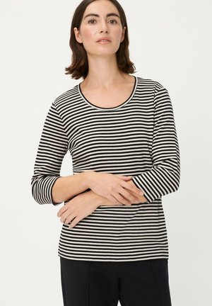 Schwarz-weiß gestreiftes Langarmshirt mit rundem Ausschnitt und tailliertem Schnitt, präsentiert über dunkler Hose. Weiche Stoffstruktur, legeres Design.