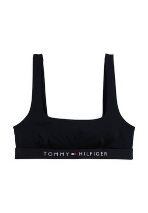 Čierny crop top bralet vyrobený z hladkej tkaniny so širokými ramienkami a elastickým pásom s logom obsahujúcim "TOMMY HILFIGER" v bielej a červenej farbe.