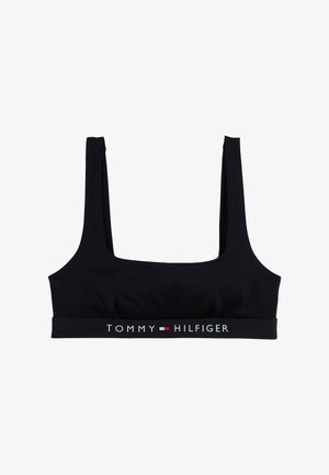 Čierny crop top bralet vyrobený z hladkej tkaniny so širokými ramienkami a elastickým pásom s logom obsahujúcim "TOMMY HILFIGER" v bielej a červenej farbe.