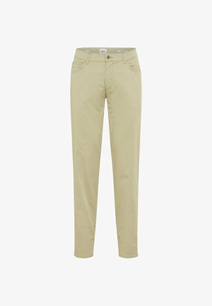 Beżowe, dopasowane, casualowe spodnie z guzikiem z przodu, szlufkami na pasek oraz kieszeniami z przodu i z tyłu, prezentowane na białym tle.