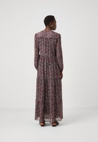 Rochie maxi de culoare roșu închis cu imprimeu floral. Mâneci lungi, talie strânsă, partea de jos în straturi și overlay transparent cu o siluetă fluidă.