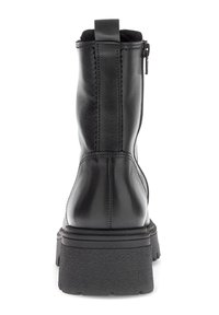 Sort læder støvle til midten af læggen med tyk struktureret sål, bageste trækflap og sideskene, vist fra bagsiden på en hvid baggrund.