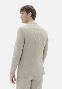 Beige Leinenblazer mit strukturierter Oberfläche, einreihigem Design, aufgesetzten Revers und Knöpfen an den Ärmeln. Rückansicht gezeigt.