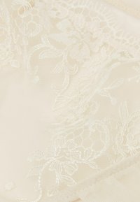 Tessuto di pizzo avorio con ricami floreali e motivi esagonali, caratterizzato da texture delicate e dettagli intricati in tutto.