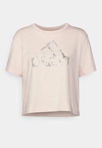 T-shirt à manches courtes et coupe courte en coton rose doux avec un logo argenté texturé imprimé sur la poitrine, doté d'un col rond et d'une coupe décontractée.