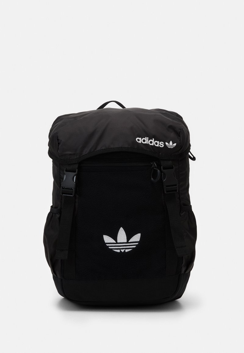 Sac à dos noir Adidas avec un rabat, arborant un logo blanc sur le devant et un panneau en tissu texturé. Bretelles réglables incluses.
