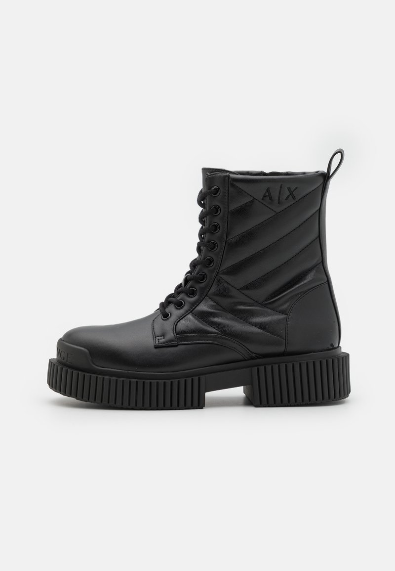 Bottines noires en cuir lisse avec des détails matelassés. Semelle épaisse à nervures, bout rond et logo embossé à l'arrière. Design à lacets.