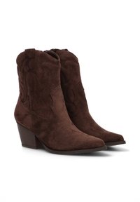Botas de cowboy de ante marrón con punta afilada y tacón apilado. Presenta costuras decorativas a lo largo de los lados y un diseño ligeramente cónico.