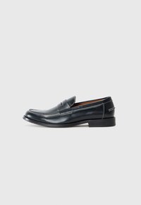 Black leather loafers with a rounded toe, featuring white stitching detail and a slightly raised heel. Smooth finish, simple design.