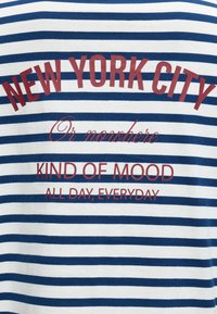 Tissu rayé bleu et blanc avec un texte rouge disant « New York City ou nulle part, une ambiance comme ça toute la journée, tous les jours. »