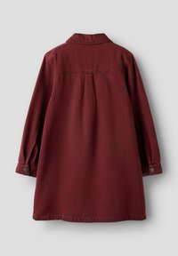 Veste en tissu doux de couleur bordeaux, avec un col, des manches longues avec des poignets à boutons et un détail de yoke à l'arrière.