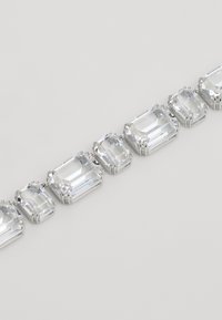 Silver-tone bracelet featuring multiple rectangular clear stones, each set in pronged clasps, varying in size and aligned in a row.