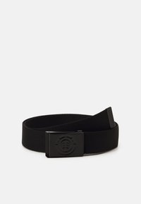 Cinturón tejido negro con una textura de tela suave y hebilla metálica rectangular con un diseño circular. Longitud ajustable para un ajuste seguro.