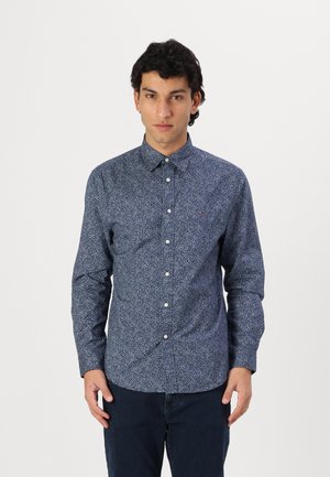 Camisa de botones navy con un patrón floral, de mangas largas y cuello clásico. Fabricada con un tejido ligero, cuenta con botones blancos.