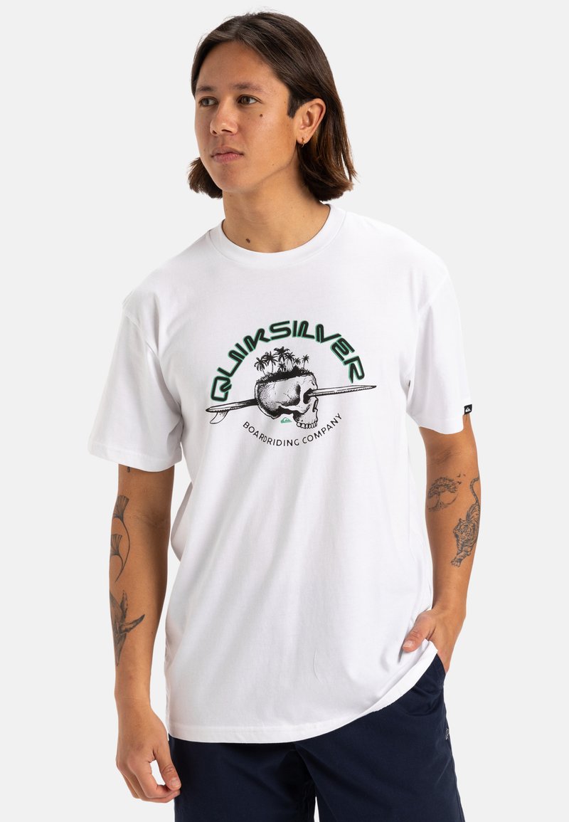 Camiseta de algodón blanca con un diseño gráfico de una calavera con palmeras, texto "Quiksilver" en verde y mangas cortas.