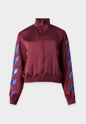 Veste bordeaux zippée avec col haut et ourlet élastique, avec des bandes diagonales en dentelle bleue sur les deux manches.