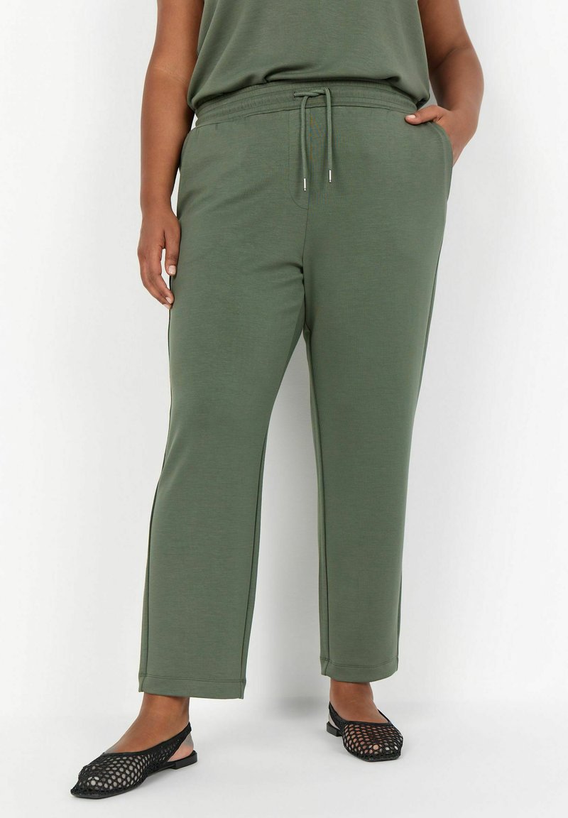 Olijfgroene joggingsbroek van zacht materiaal, voorzien van een elastische tailleband met koord, zijzakken en een relaxte pasvorm.