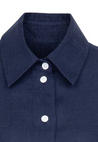 Colletto di camicia in lino blu navy con design elegante, caratterizzato da tre bottoni bianchi sul davanti e una finitura in tessuto testurizzato.