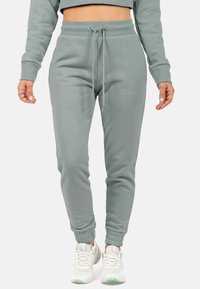 Lichtgroene joggingbroeken van zacht materiaal, met een elastische tailleband met trekkoord, zijzakken en aansluitende boorden.