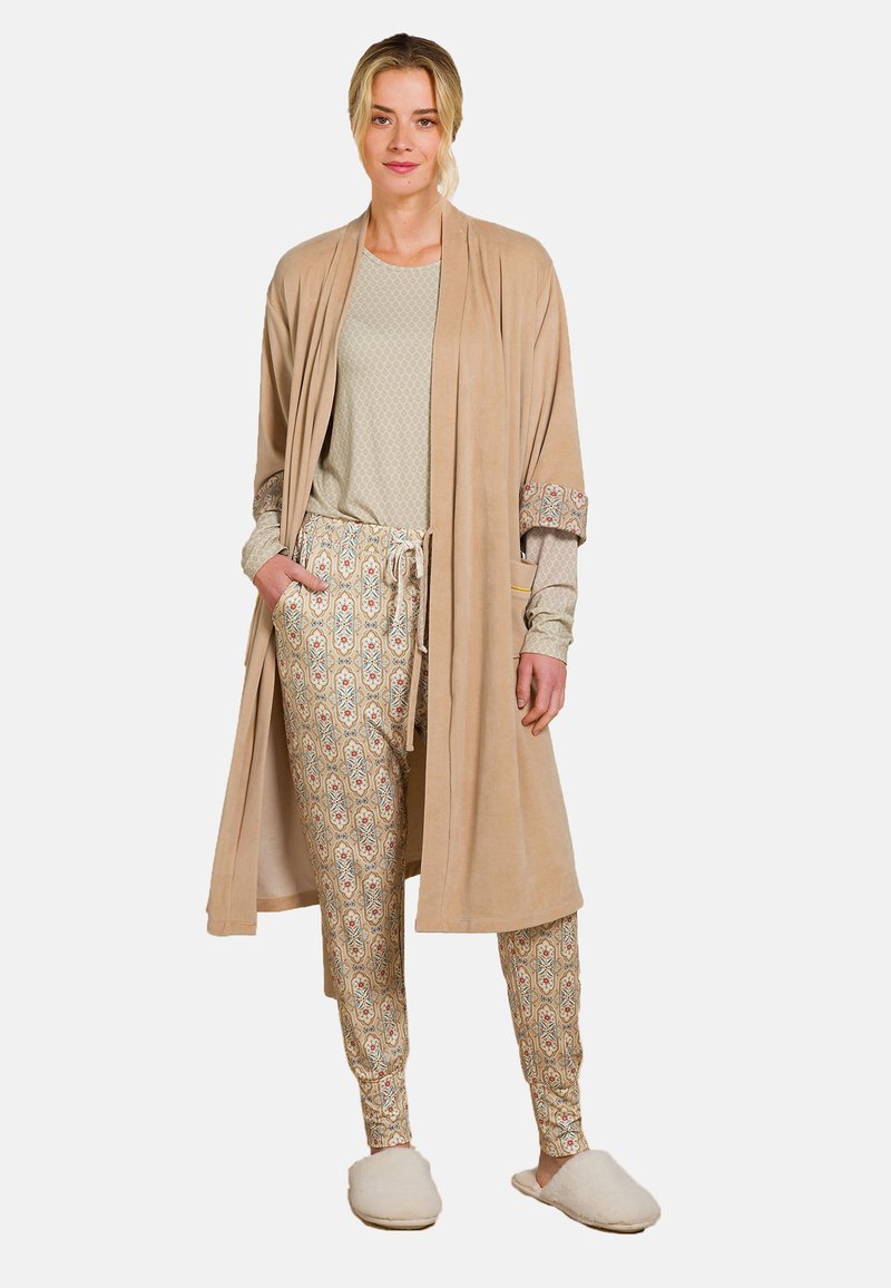 Beige, long, plush robe over a light patterned top and patterned pants with an elastic waistband. Soft slippers complete the outfit.
