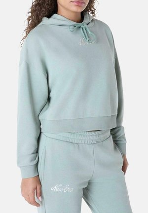 Sudadera corta de color verde claro con capucha y cordón. Material suave, puños acanalados y logo bordado de "New Era" en el pecho.