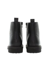 Pari mustapasta nahasta valmistettu nilkkabootit nähtynä takaa, joissa on vetolenkit ja sivuvetoketjut tukevilla kumipohjilla.